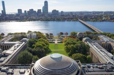 Aerial photo of the MIT dome and Killian Court facing the Charles River and Boston.