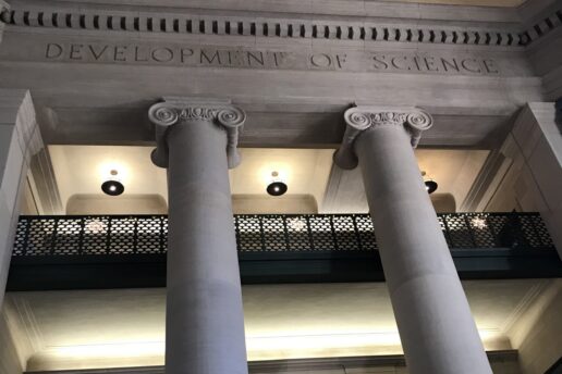 Photo of columns and balconies in MIT Lobby 7 with the etched words 