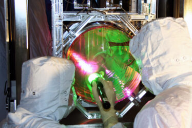 LIGO optics technicians examining one of LIGO's mirrors.