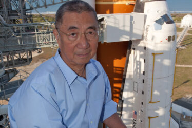 Professor Ting poses in front of the Space Shuttle Endeavor before it launches with AMS-02