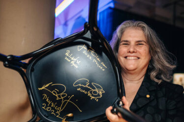 2020 Nobel Laureate and physics alumnae Andrea Ghez '87 poses with signed chair.