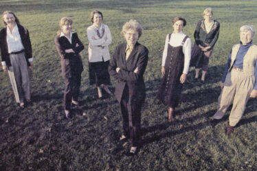 Seven MIT faculty pose with Killian Court in background