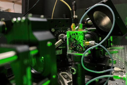 closeup of lab equipment under green light showing a rectangular sensor with cables