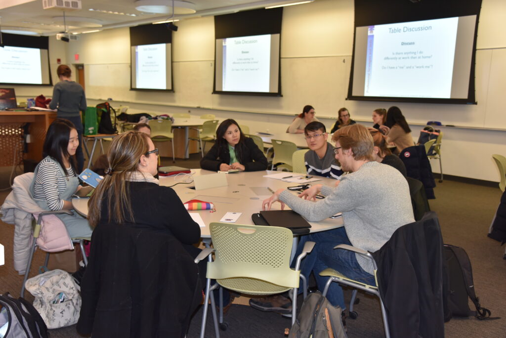 Students discuss sitting at round table in classroom