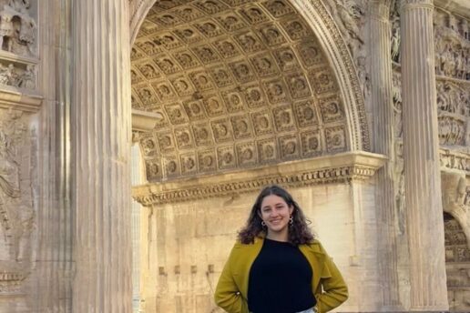 Leela Fredlund poses in front of a large stone archway