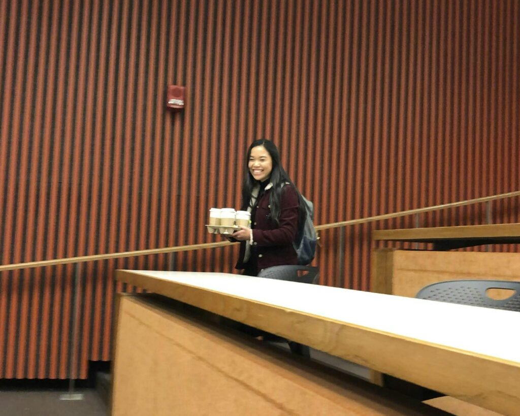 Minh-Thi enters lecture hall holding many coffees