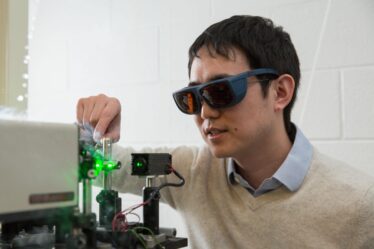 Professor Long Ju wears eye protection while working on experiment with lasers