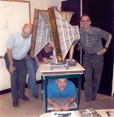 The All-Sky Monitor team assembles around the X-ray monitoring instrument.