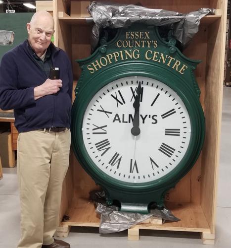 Hale Bradt stands beside refurbished Almy's Clock of Salem, MA